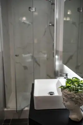 a bathroom with a sink and a glass shower at Relais Manzoni in Rome