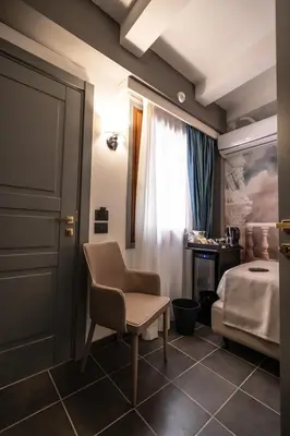 a bedroom with a bed and a chair and a desk at Relais Manzoni in Rome