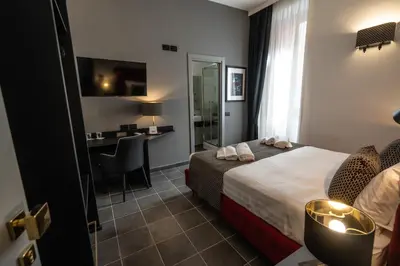 a hotel room with a bed and a desk at Relais Manzoni in Rome