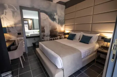 a bedroom with a large bed and a mirror at Relais Manzoni in Rome