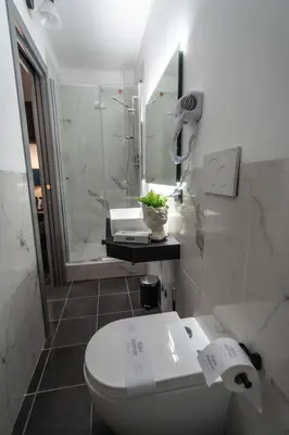 a white bathroom with a toilet and a shower at Relais Manzoni in Rome