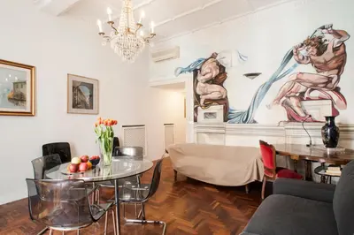a living room with a table and a chandelier at Santa Cecilia Apartment in Via del Corso in Rome