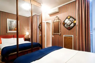 a hotel room with two beds and a clock on the wall at Santa Cecilia Apartment in Via del Corso in Rome