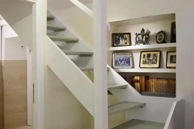 a white staircase with bookshelves in a house at Navona Charming Flat in Rome