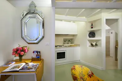 a kitchen with a table and a mirror on the wall at Navona Charming Flat in Rome