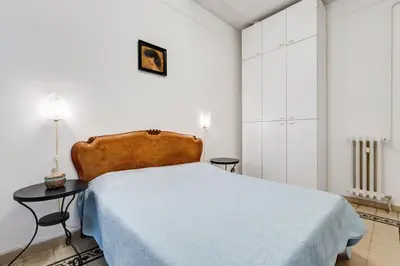 a white bedroom with a bed and a table at Appartamento con 3 camere da letto e 2 bagni vicino al Vaticano in Rome