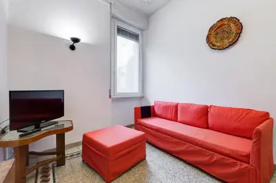 a living room with a red couch and a tv at Appartamento con 3 camere da letto e 2 bagni vicino al Vaticano in Rome