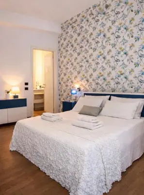 a bedroom with a white bed with towels on it at Comfy Vatican Suite in Rome