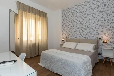 a bedroom with a bed with a blue and white wallpaper at Comfy Vatican Suite in Rome