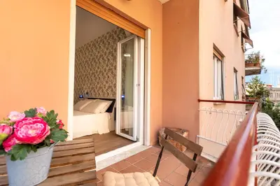 a balcony with a vase of flowers and a bed at Comfy Vatican Suite in Rome