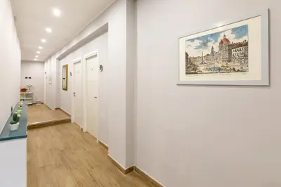 a hallway with white walls and a painting on the wall at Comfy Vatican Suite in Rome