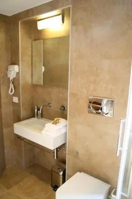 a bathroom with a sink and a mirror and a toilet at Cardilli Luxury Rooms in Rome