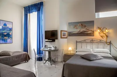 a bedroom with a bed and a table and a tv at Roma Central Guest House in Rome