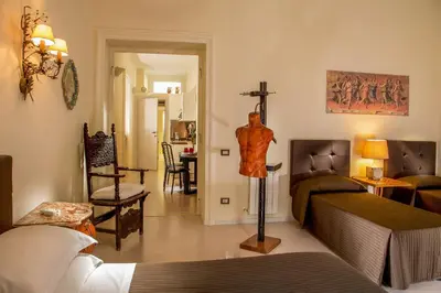 a room with two beds and a cross on the wall at Roma Central Guest House in Rome