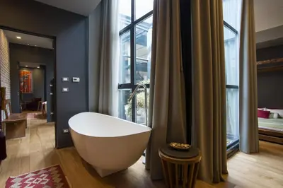 a bathroom with a bath tub in front of a window at Loft Spazio Panieri Unique place in Trastevere in Rome