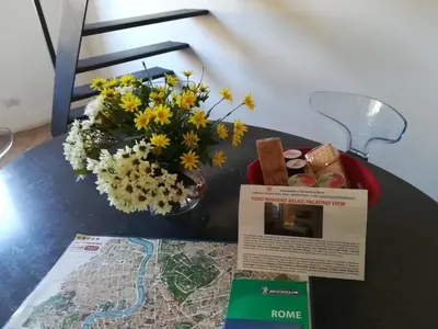 a table with a map and flowers on it at Foro Romano Palatino View Relais in Rome