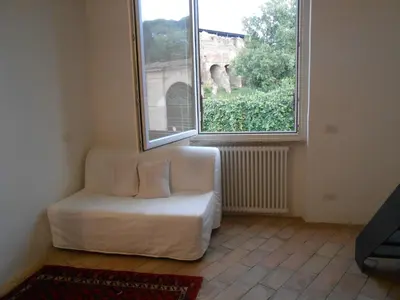 a white couch in a room with a large window at Foro Romano Palatino View Relais in Rome