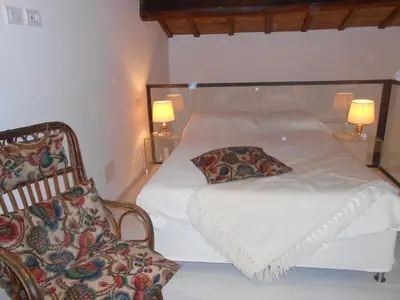 a bedroom with a white bed and a chair at Foro Romano Palatino View Relais in Rome