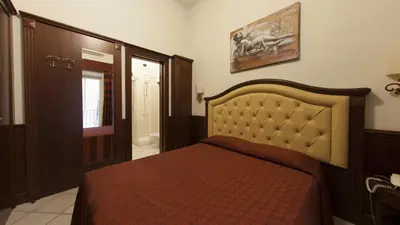 a bedroom with a bed with a orange bedspread at Domus Augusta in Rome