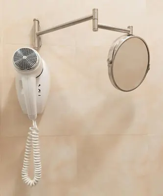 a hair dryer and a mirror on a wall at Domus Augusta in Rome