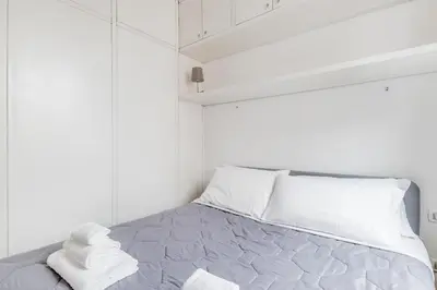a white bedroom with a bed with towels on it at Giulia's holidays in Rome