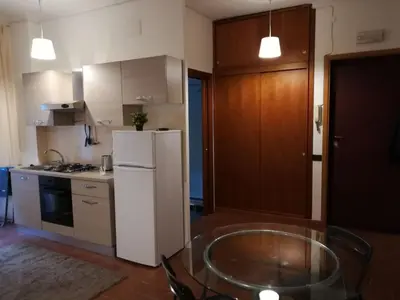 a kitchen with a white refrigerator and a glass table at Roma Metro Furio Camillo in Rome