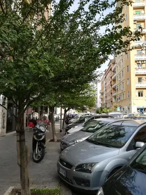 a motorcycle parked next to a row of parked cars at Roma Metro Furio Camillo in Rome