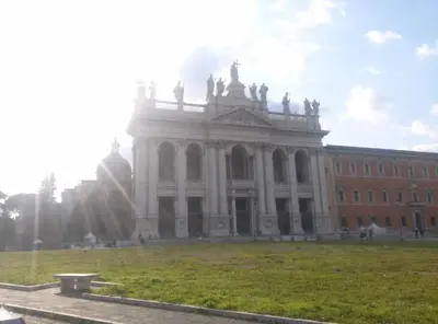 a large building with a grass field in front of it at Roma Metro Furio Camillo in Rome