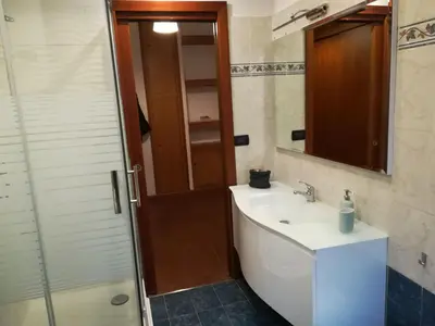 a bathroom with a sink and a shower with a mirror at Roma Metro Furio Camillo in Rome