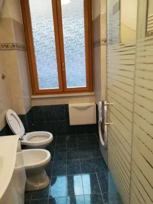 a bathroom with two toilets and a window at Roma Metro Furio Camillo in Rome