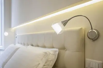 a bedroom with a bed with a lamp on the wall at Quiriti Vatican Relais in Rome
