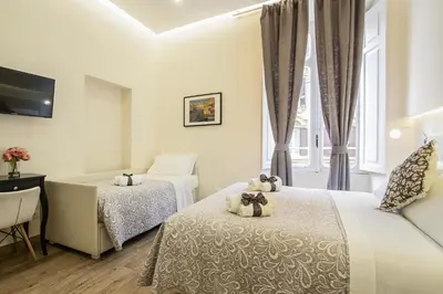 a hotel room with two beds and a window at Quiriti Vatican Relais in Rome