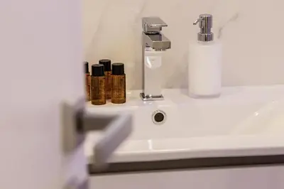 a bathroom sink with a faucet and a bottle on it at Quiriti Vatican Relais in Rome