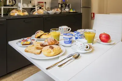 a table with breakfast foods and drinks on it at Quiriti Vatican Relais in Rome