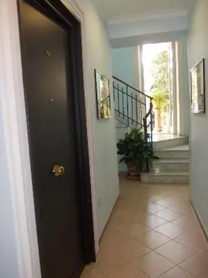 a hallway with a black door and a staircase at Residence Lodi in Rome