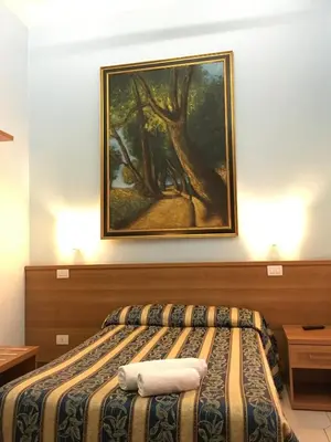 a bedroom with a bed with a painting on the wall at Hotel Bolognese in Rome