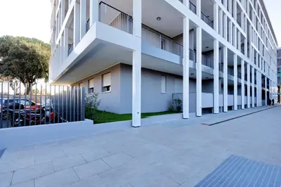a white building with a parking lot next to it at YCH-DELIZIOSO Monolocale con TERRAZZO in Rome