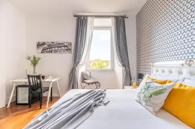 a bedroom with a bed and a desk and a window at Suite 36 in Rome