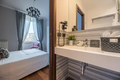 a bathroom with a bed and a sink and a mirror at Suite 36 in Rome