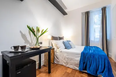 a bedroom with a bed and a desk and a window at Suite 36 in Rome
