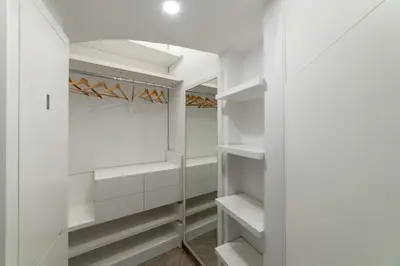 a white walk in closet with white shelves at Domus Quiritum Elite, Vatican luxury apartment in Rome
