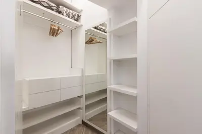 a white walk in closet with white shelves at Domus Quiritum Elite, Vatican luxury apartment in Rome