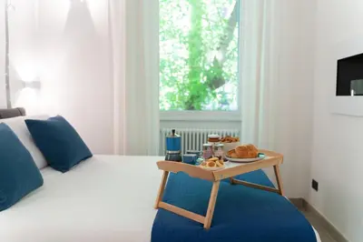 a bedroom with a bed and a tray of food on a table at Domus Quiritum Elite, Vatican luxury apartment in Rome