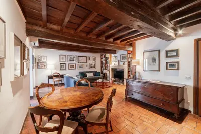 a living room with a wooden table and chairs at Domus Quiritum Charming, Appartamento d'Epoca a Campo de' Fiori in Rome