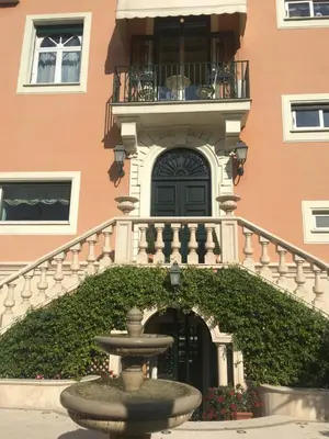 a fountain in front of a building with a balcony at B&B VILLINO MARGHERITA in Rome