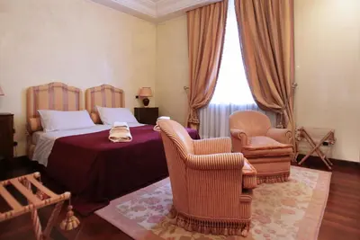 a bedroom with a bed and two chairs at B&B VILLINO MARGHERITA in Rome