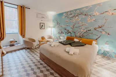 a bedroom with a large bed with a floral wall at L'Agata (Trastevere) in Rome