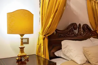 a bedroom with a bed and a table with a lamp at Residenza Sinibaldi - XVII century experience in Rome