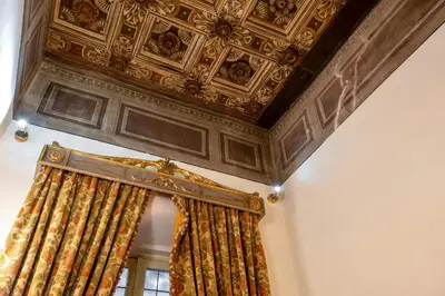 a room with a curtain and a coffered ceiling at Residenza Sinibaldi - XVII century experience in Rome