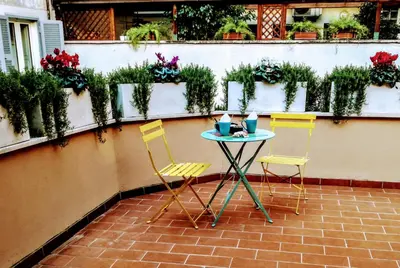 a table and chairs on a patio with plants at CIVICO 7 Holiday Rooms in Rome